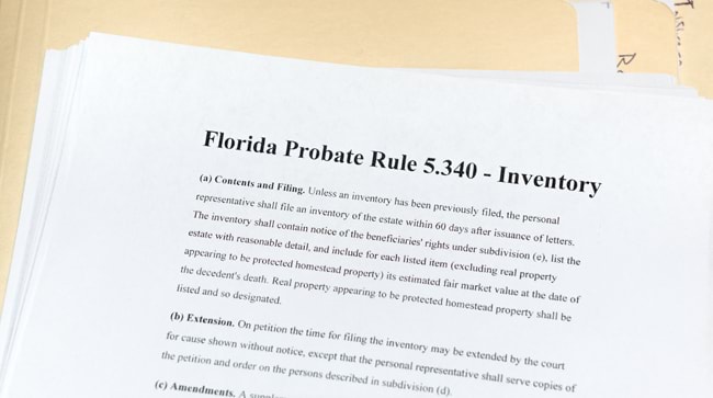 A sheet detailing Florida's probate rule 5.340, placed on top of a stack of probate inventory documents and paperwork