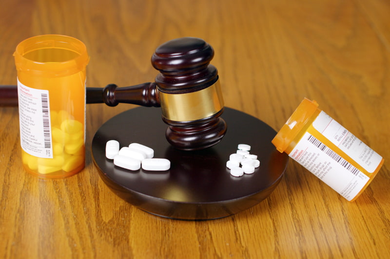 Medication bottle next to a judge’s gavel symbolizing legal defense for pharmacists