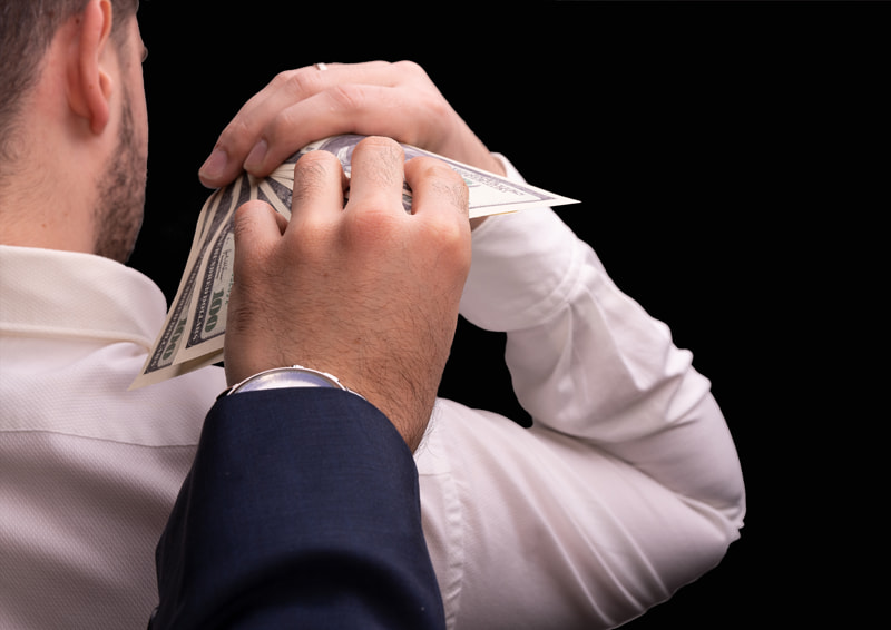 Man giving several hundred dollars above his shoulder with a hand reaching and grabbing the money